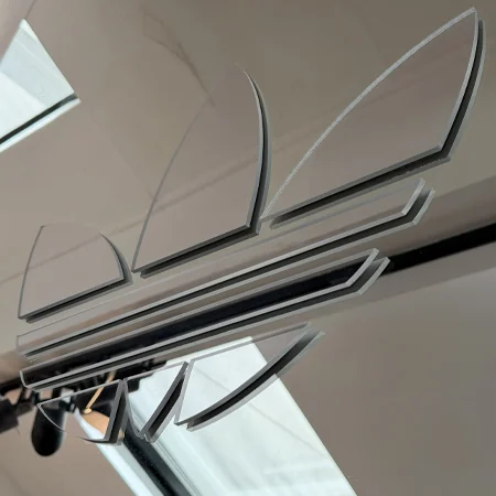 Logo trèfle adidas découpé en Plexiglas dans le showroom parisien