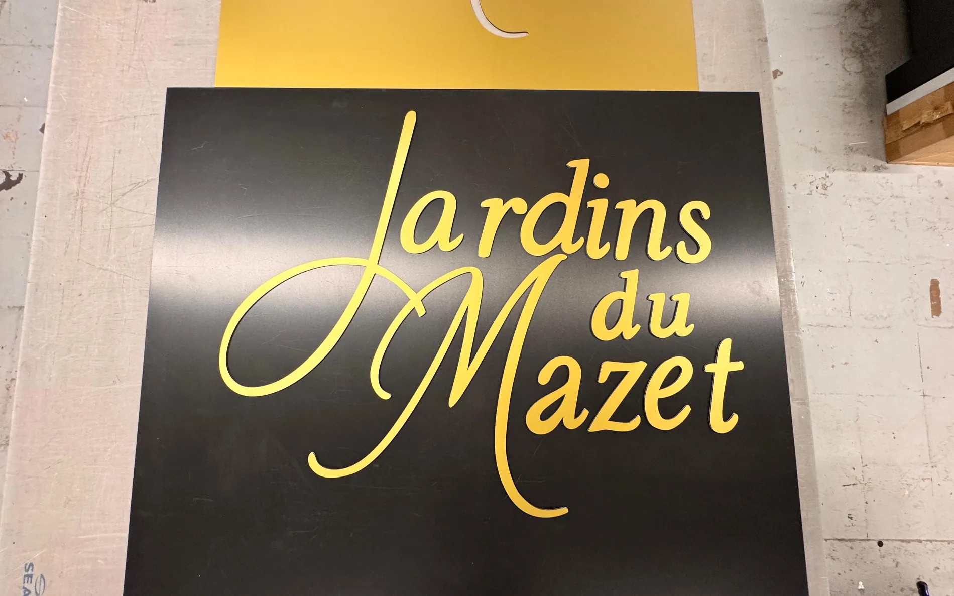 Panneau de signalétique intérieure en finition laiton brossé : lettrage doré élégant sur fond sombre